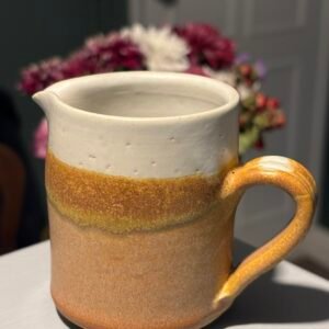 Vintage studio pottery, handmade ceramic cream jug with a white and brown glaze.