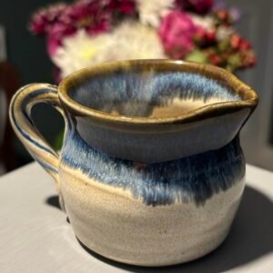 Beautiful vintage handmade ceramic jug with a blue and tan drip glaze.